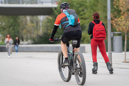 Man cycling and woman skating exercising together in rio Park , Madrid ,Spainの写真素材