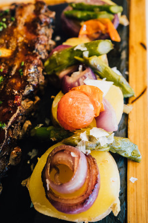 close up of roasted potatoes and vegetables accompanying honey Bbq Pork Ribsの写真素材