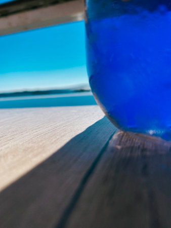 Abstract close up Refreshing photo of a Glass of Water in hot summer in front of the oceanの写真素材