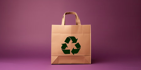 Recycled paper bag with recycling symbol isolated on pink background with copy spaceの素材