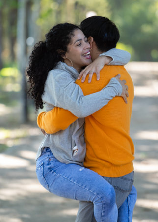 Young latin couple smiling confident hugging each other at parkの写真素材