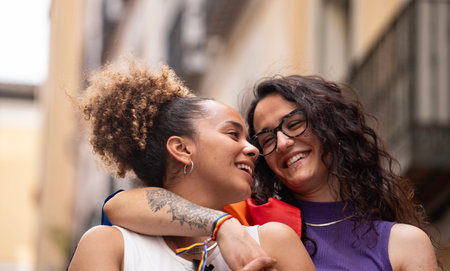 Headshot of two multiethnic lesbian women in love hugging and smiling enjoying time together.の写真素材