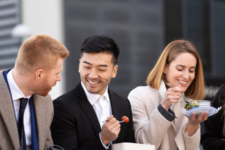 Portrait of business people having lunch in an urban park near their office.の写真素材