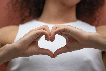Man showing hand sign heart on his chest.Man making a heart shape with his hands.の写真素材