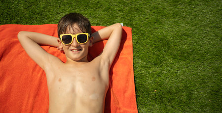 Smiling boy with sunglasses relaxing on a sunny dayの写真素材