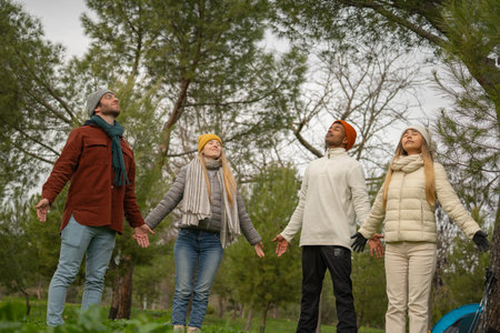 Multiethnic group of friends enjoying fresh air and connecting with nature during camping trip,...