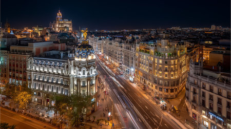 Illuminated gran via street with blurring car light tails leading through the heart of madridの写真素材