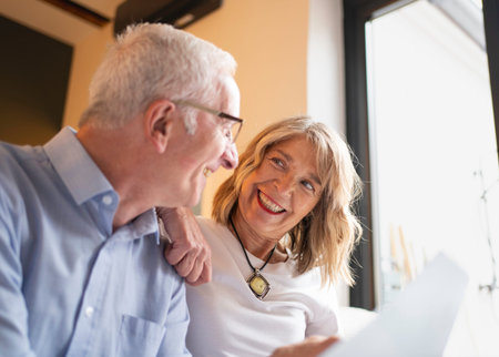 Happy senior couple smiling and looking at each other, enjoying a relaxed moment at home