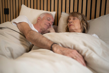 Senior couple finding tranquil rest and intimacy while sleeping togetherの写真素材