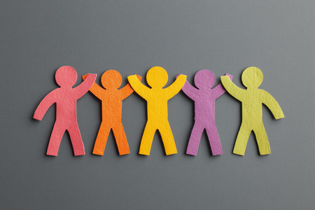 Multicolored paper people standing in a row, conceptually showing teamwork, togetherness, and inclusionの写真素材