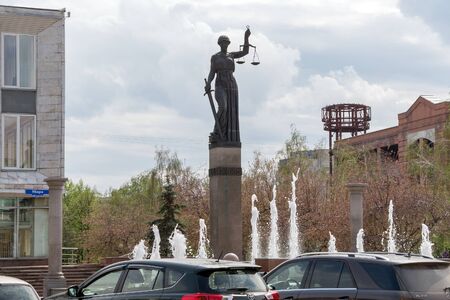 The fountain and the statue of Themis - the goddess of justice near the Courthouse of the Krasnoyarsk Territory, on Prospekt Mira on a cloudy spring day. Krasnoyarsk. Kranoyarsk region. Russia.のeditorial素材