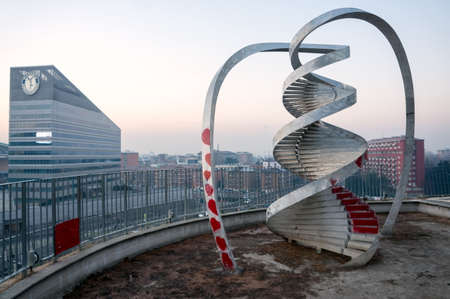 Sculpture spiral of time on the observation deck in the public park Portello against the background of the office building in the early winter morning. Milan. Italyのeditorial素材