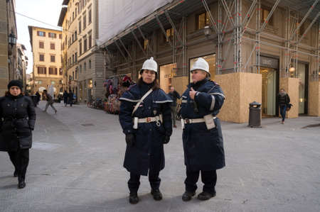 Two female police officers in a special uniform keep order on the city street. Florence, Italy.のeditorial素材