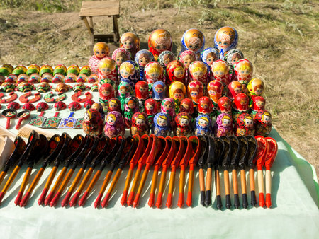 Wooden spoons, nesting dolls and other Russian folk souvenirs stand on the counter against the...