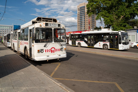 Krasnoyarsk, Krasnoyarsk Region, RF - July 19, 2021: White trolleybuses are waiting for passengers at a public transport stop on the Privokzalnaya Square of the city's main railway station.のeditorial素材