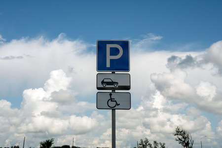 Road sign Disabled parking on the background of a beautiful cloudy summer sky.の写真素材
