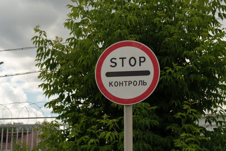 A road sign near the fence with barbed wire, prohibiting entry into the territory with the...