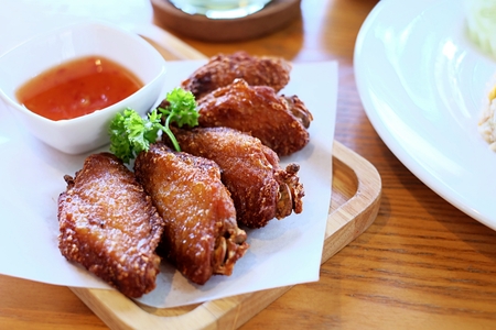 Fried chickens with sweet sauce on the wooden plate.の写真素材