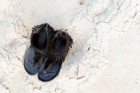 The black shoes on the white sand.の写真素材