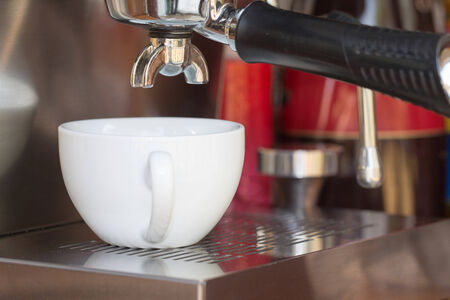 close up of coffee machine makes coffee and white cupの写真素材