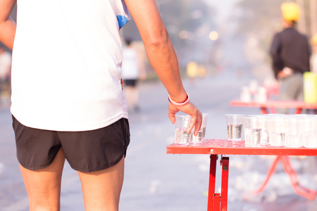Runner take a water in a marathon raceの写真素材