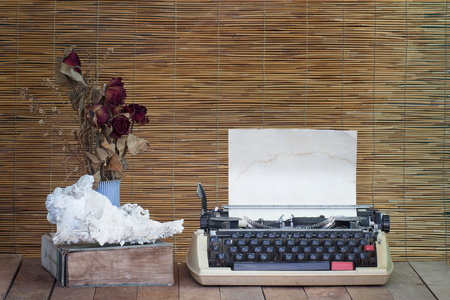 Still life with old typewriter ,book with dry rose flowers on wooden tableの写真素材