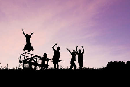 children playing silhouette on color of skyの写真素材