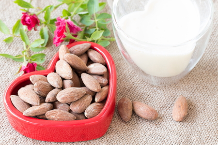 Rose, Almond milk with almond seed, almond  organic healthy nut vegan vegetarian drink wood teak background rustic still lifeの写真素材