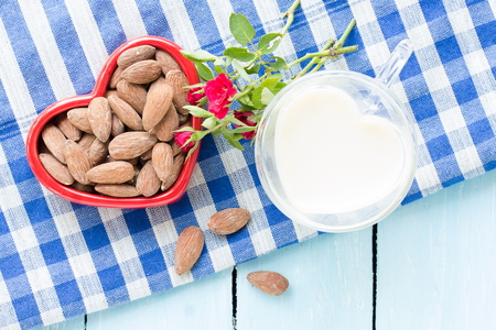 Rose, Almond milk with almond seed, almond  organic healthy nut vegan vegetarian drink wood teak background rustic still lifeの写真素材