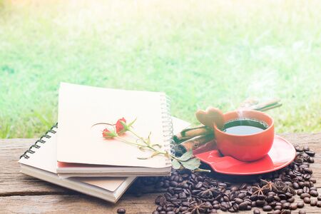 Love letter notepad, red roses and coffee cup on wooden table. Valentines day conceptの写真素材