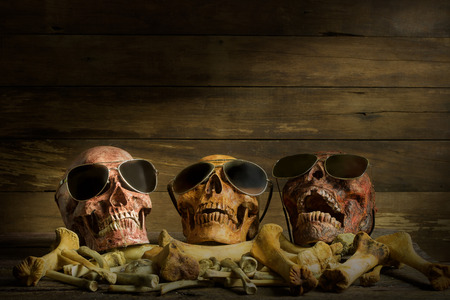 Awesome pile of skull human wear glasses and bone on wood background, Star Sing a song. Still Life style, selective focus,の写真素材