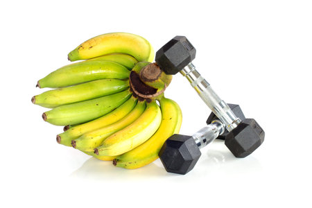 Fitness dumbbells with banana isolated on white backgroundの写真素材