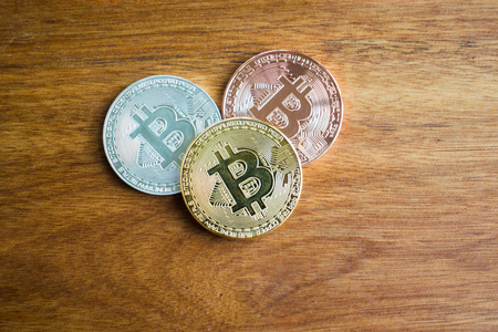 golden bitcoin, silver bitcoin, bronze bitcoin on woodenの写真素材