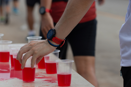 Marathon runner picking up mineral salt water at service pointの写真素材