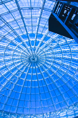 The original design of glass and metal in the form of a dome of a skyscraper, blue skyの写真素材