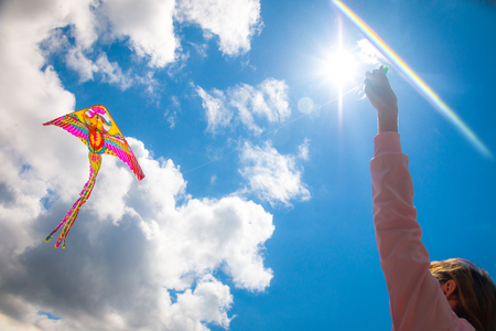 Happy Girl launches a bright kite on clear dayの写真素材