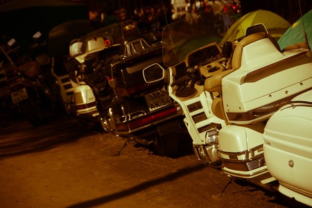 Vintage custom motorcycle cafe racer motorbike with lamp lights turned on. One with grill headlight another with tape cross over optic on empty rooftop parking lot during sunset. Hipster lifestyle.の写真素材