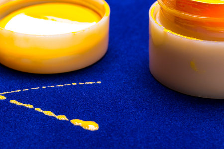 bright colors for a manicure on blue background. spilled paint yellow. sloppy