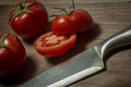 The kitchen knife and cut the tomatoes on the boardの写真素材