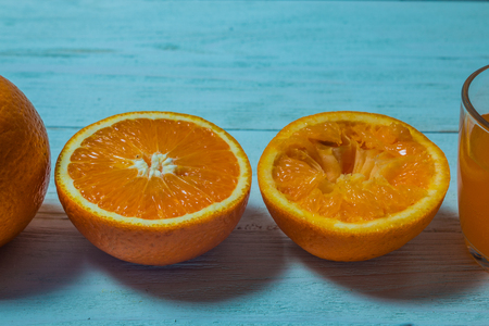 A glass of fresh orange juice with sliced oranges on a wooden table. Preparation of fresh orange juiceの写真素材