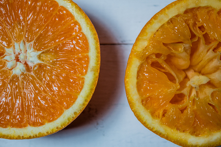A glass of fresh orange juice with sliced oranges on a wooden table. Preparation of fresh orange juiceの写真素材