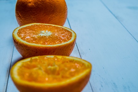 A glass of fresh orange juice with sliced oranges on a wooden table. The preparation of fresh orange juice is primordial to product advertisingの写真素材