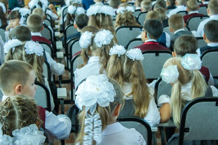 many children sit dressed in the assembly hall at a concert dedicated to the Day of Knowledge Day on September 1. the picture is taken from the backの写真素材