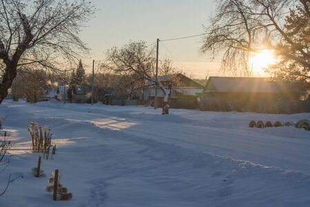 The main street of a Russian village in winter at sunset in freezing weatherの写真素材