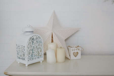 decorative Christmas candles, stars and a lantern on the fireplaceの写真素材