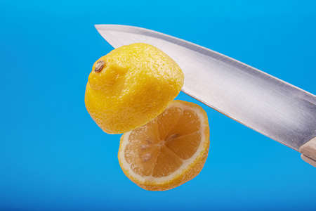 sliced juicy lemon on a blue background with the effect of levitation, artistic fruitの写真素材