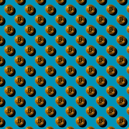 flat seamless pattern of gold bitcoin coins on a blue background with a shadow, cryptocurrencyの写真素材