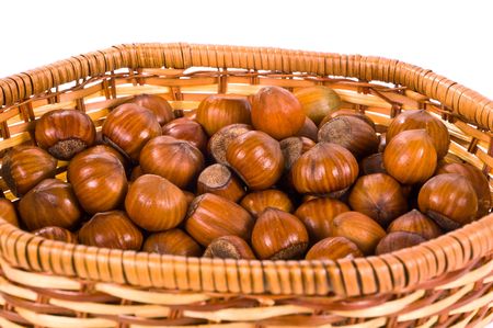 Hazelnut in a wattled basket on the white の写真素材