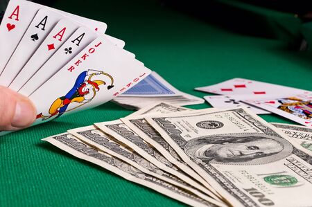 Poker cards showing poker and dollars on green clothのeditorial素材