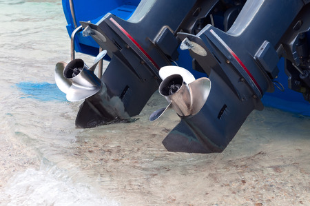 Screws outboards hanging over the sea waterの写真素材